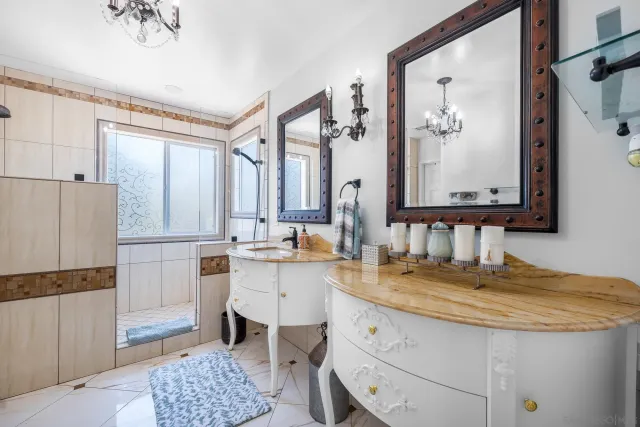 a bathroom with a granite countertop sink a mirror a vanity and a shower