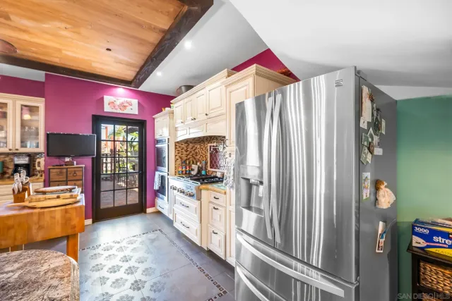 a living room with furniture a flat screen tv and a refrigerator
