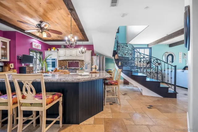 a view of a room with wooden floor and pendant lights