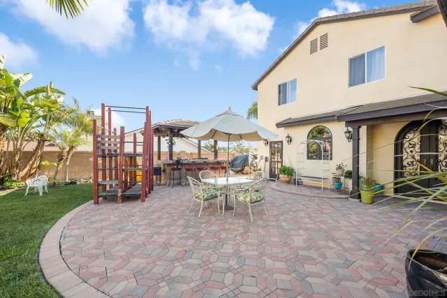 a view of a house with backyard and sitting area