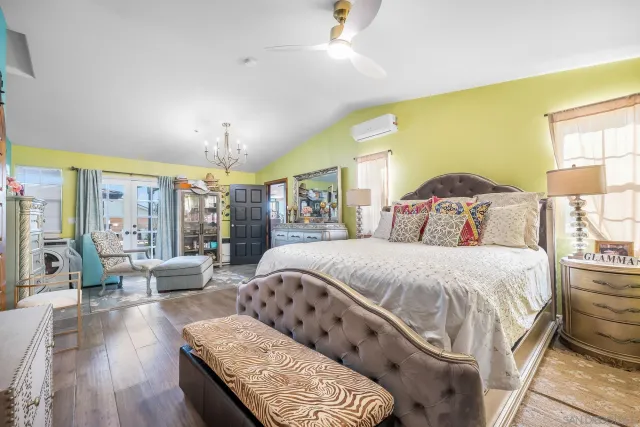 a spacious bedroom with a bed a couch and dresser in it