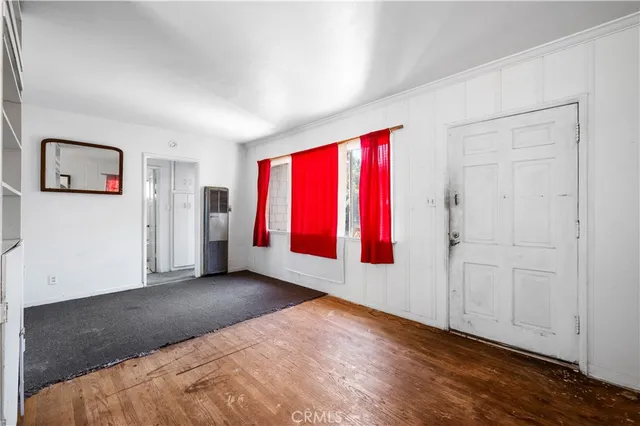 a view of empty room with wooden floor and window