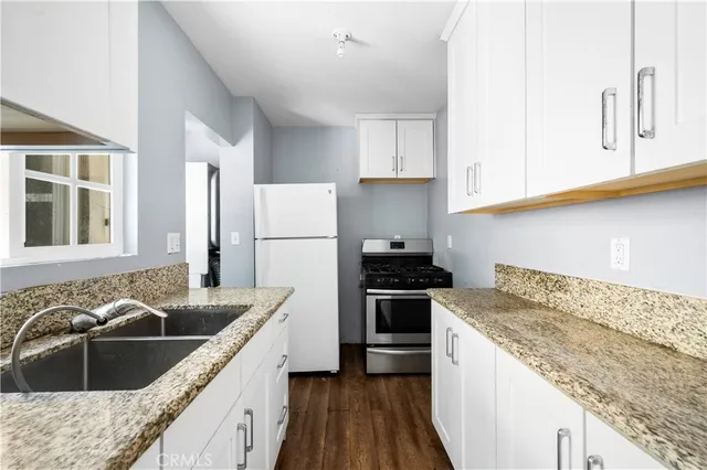 a kitchen that has a sink cabinets counter space and appliances