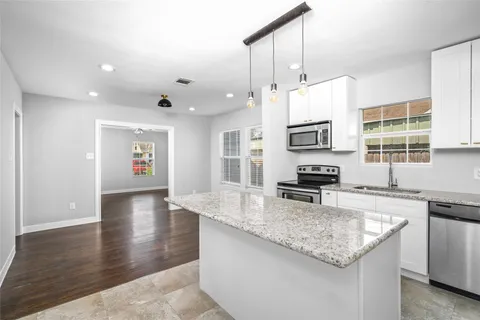 a kitchen with stainless steel appliances granite countertop a stove a sink a oven a refrigerator and a granite counter tops