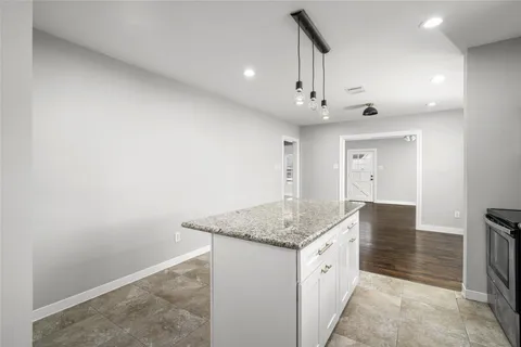 a kitchen with granite countertop a stove a sink a microwave counter space and cabinets