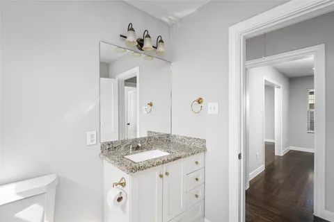 an empty room with wooden floor and a ceiling fan