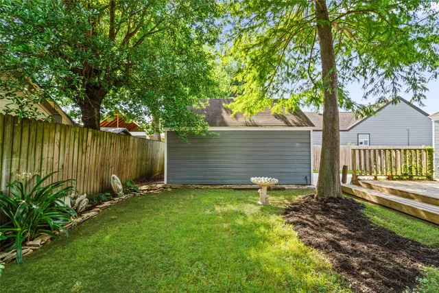 a view of a backyard with table and chairs and a large tree