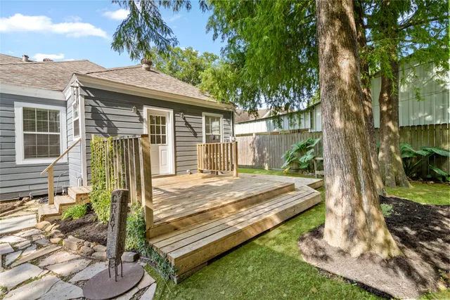 a backyard of a house with lots of green space and wooden fence