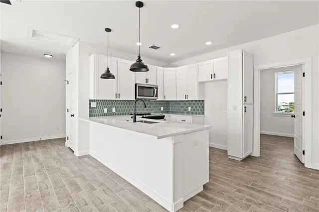 a large kitchen with stainless steel appliances kitchen island wooden cabinets a refrigerator a sink and a stove