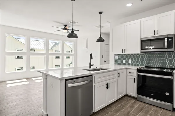 a kitchen with a sink stove and microwave