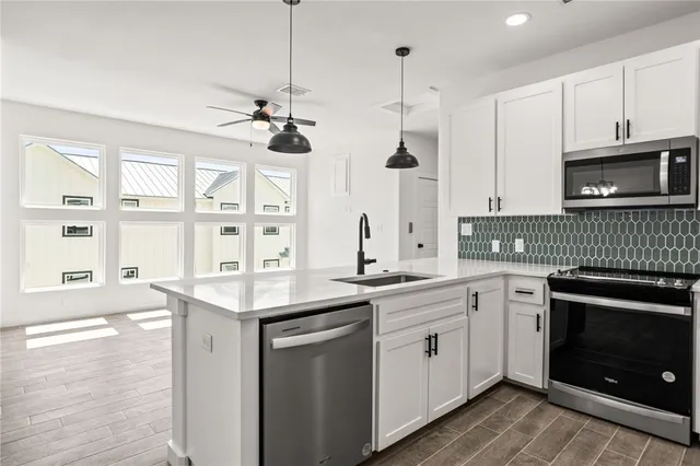 a kitchen with a sink stove and microwave