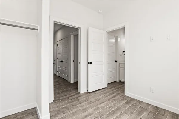 a view of an empty room with closet and a window