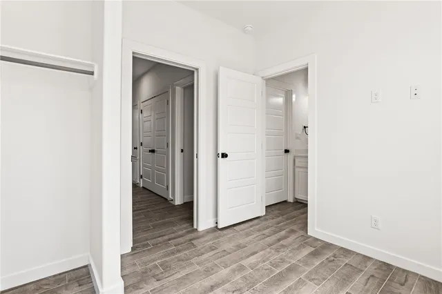 a view of an empty room with closet and a window