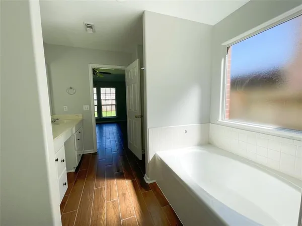 a view of a room with wooden floor and fan