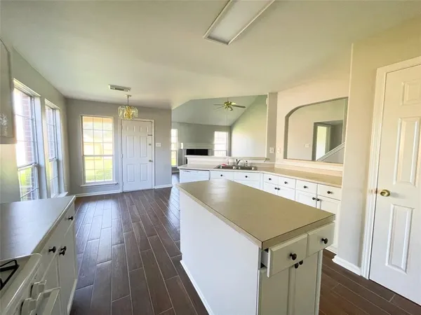 a kitchen with a sink and wooden floor