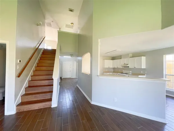 a view of a room with wooden floor and a ceiling fan