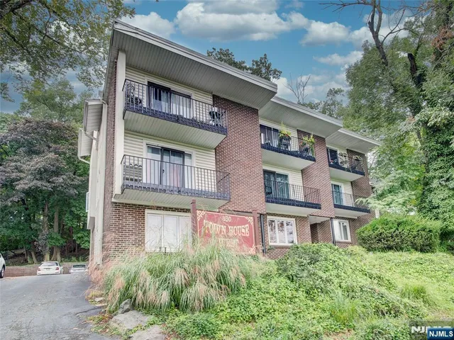 a front view of a building with a garden