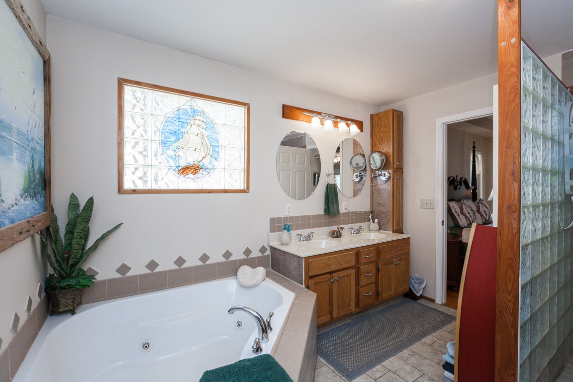 3155 Rocky Point Road Stewart, TN 37175 - Photo 21 of 44 a bathroom with a tub sink and mirror