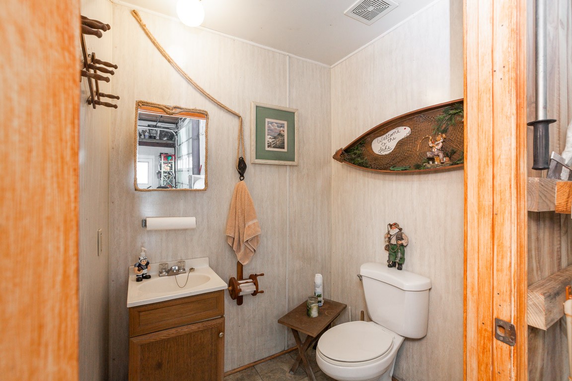 3155 Rocky Point Road Stewart, TN 37175 - Photo 32 of 44 a white toilet sitting next to a bathroom sink and vanity