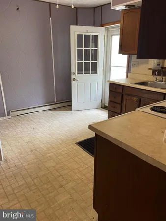 a kitchen with kitchen island a sink a stove and a window