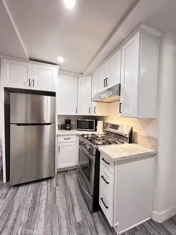 a kitchen with a refrigerator sink and cabinets