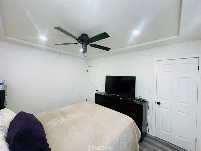 a bedroom with a bed and a flat tv screen on the dresser