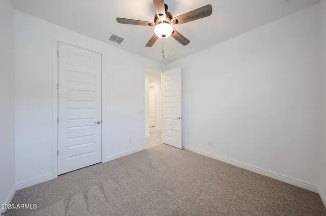 an empty room with a ceiling fan and a fan
