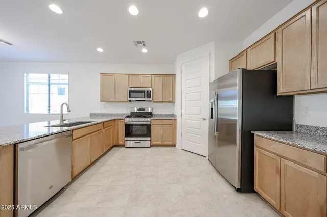 a kitchen with granite countertop appliances cabinets and a sink