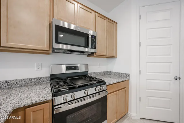 a kitchen with stainless steel appliances granite countertop a stove microwave and sink