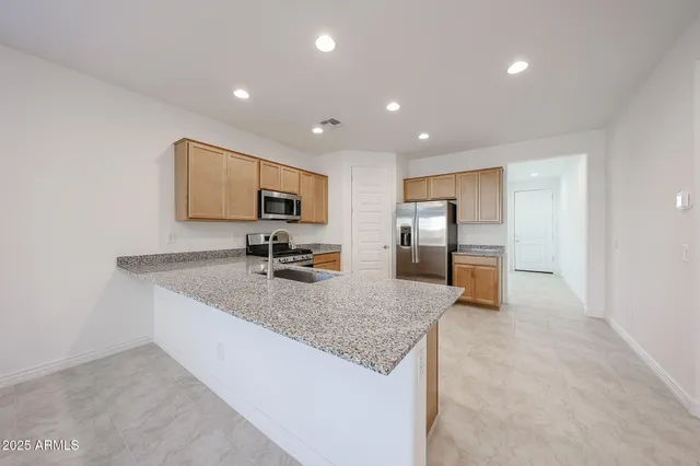 a kitchen with granite countertop a sink and stainless steel appliances