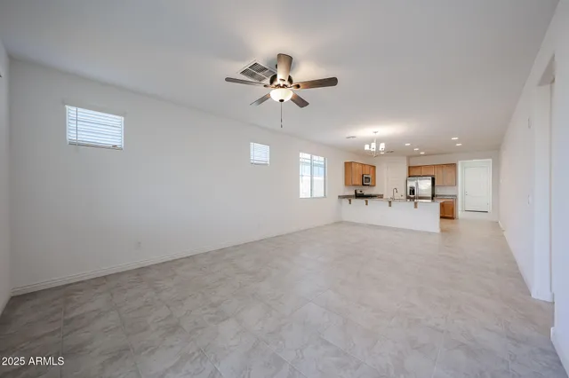 a view of a livingroom with a furniture a ceiling fan and window