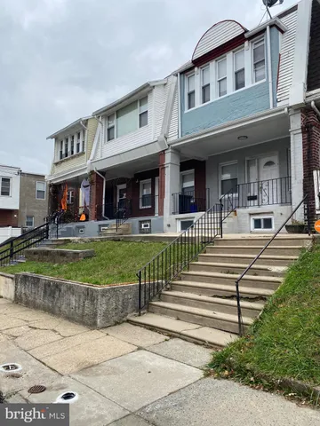 a front view of a building with a garden and plants