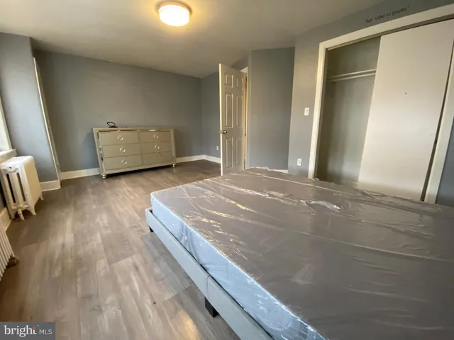 an empty room with wooden floor and mirror