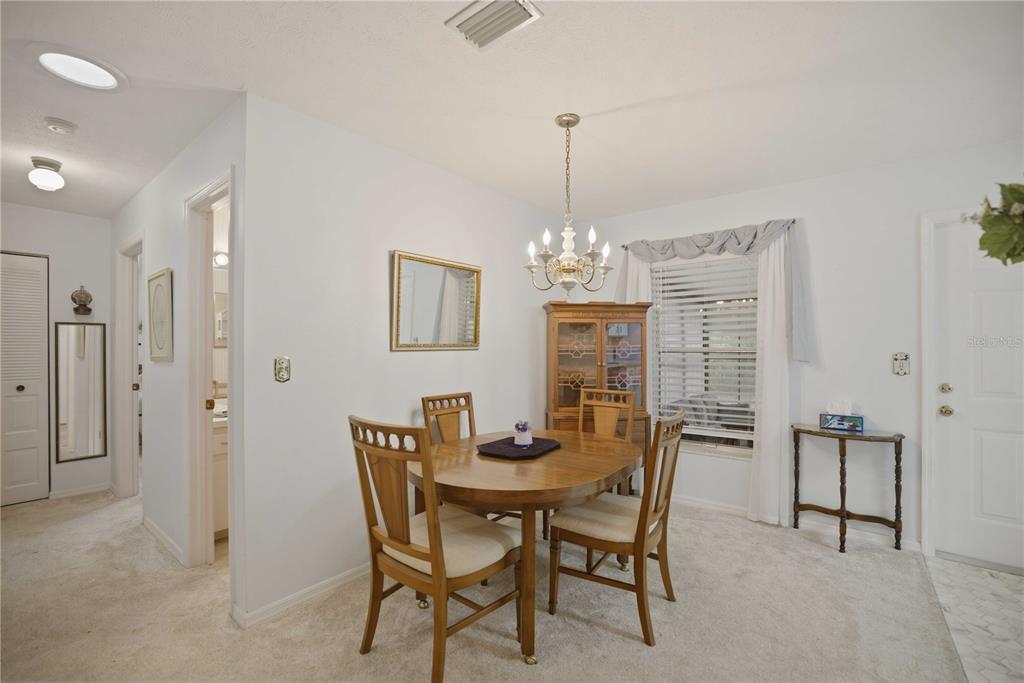 3654 Southeast 68th Street Ocala, FL 34480 - Photo 6 of 25 a view of a dining room with furniture a chandelier and wooden floor