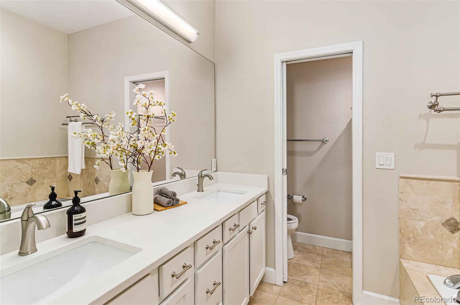2580 17th Street, Unit 202 Denver, CO 80211 - Photo 19 of 32 a bathroom with double vanity sink a mirror and shower