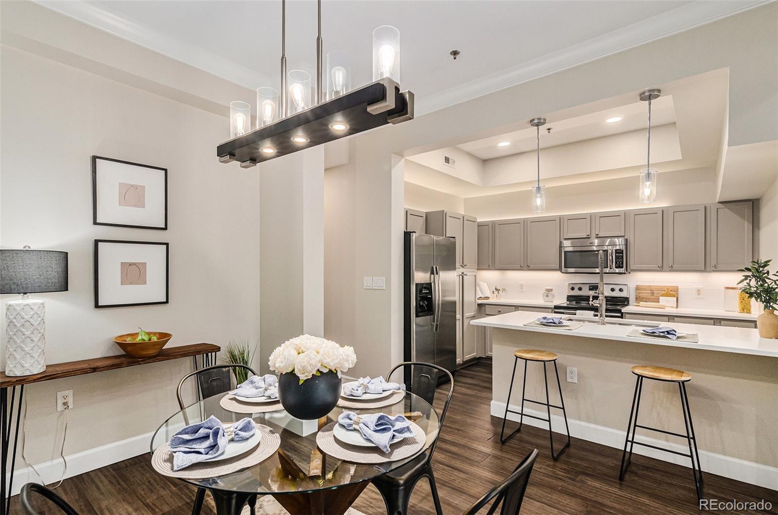 2580 17th Street, Unit 202 Denver, CO 80211 - Photo 7 of 32 a kitchen with stainless steel appliances kitchen island granite countertop a dining table and chairs with wooden floor