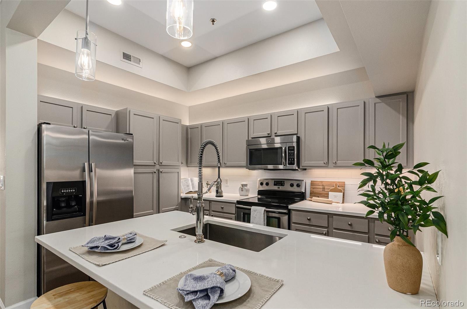 2580 17th Street, Unit 202 Denver, CO 80211 - Photo 10 of 32 a kitchen with stainless steel appliances a refrigerator a sink a stove white cabinets and couches with wooden floor