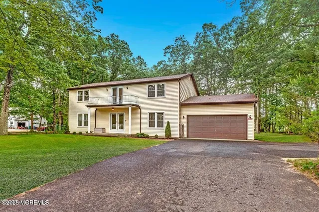 a front view of a house with yard and green space