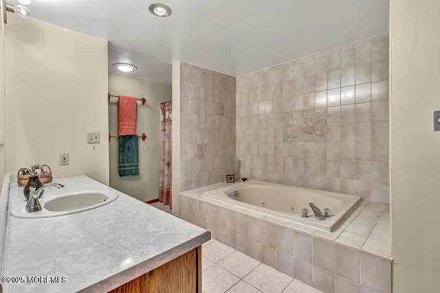 a bathroom with a tub sink and mirror