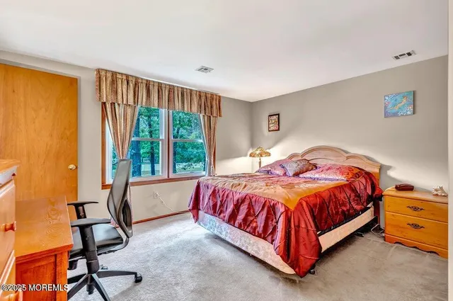 a spacious bedroom with a bed and wooden floor