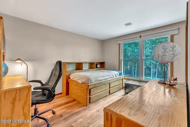 a bedroom with a bed a lamp and a large window