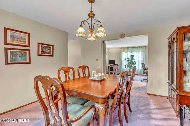 a dining room with furniture a chandelier and wooden floor