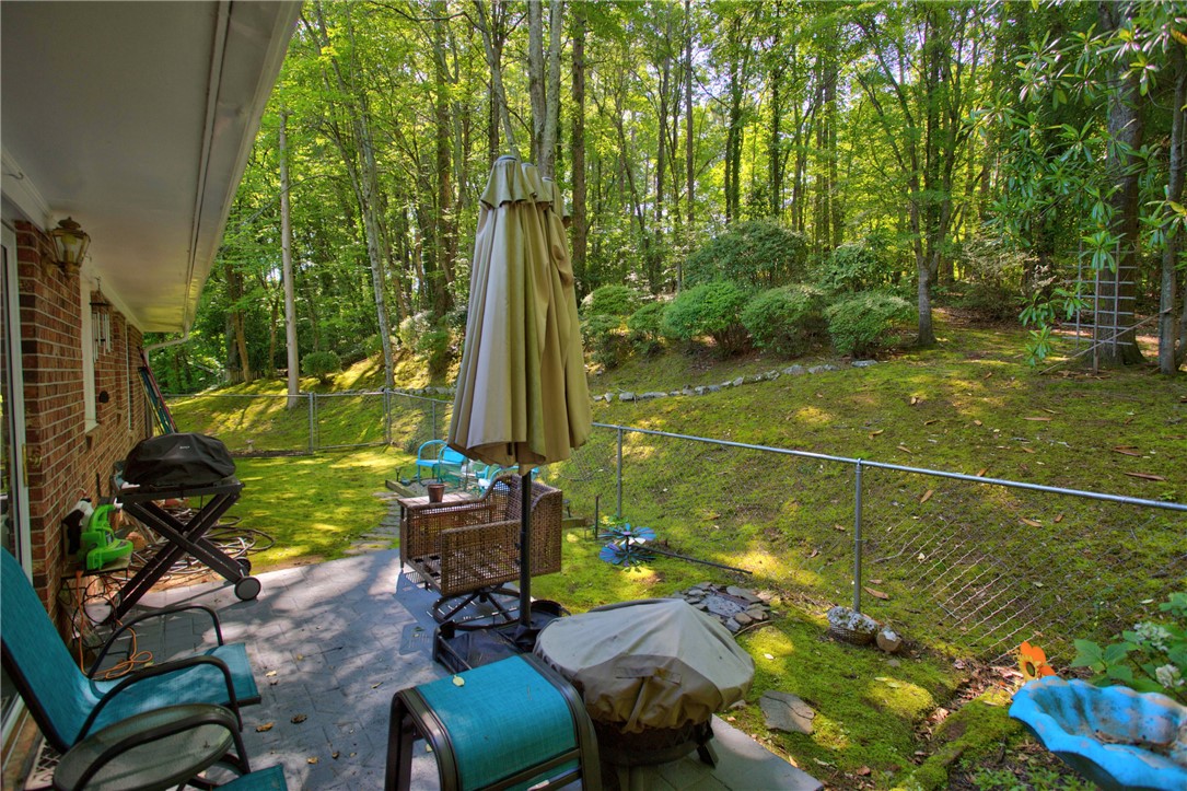 104 Laurel Lane Seneca, SC 29678 - Photo 32 of 36 A spacious patio overlooking a verdant, fenced backyard provides a serene outdoor living space.