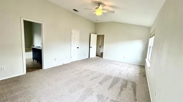 a view of an empty room with a chandelier fan