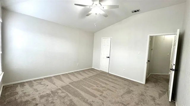 an empty room with a chandelier fan and closet