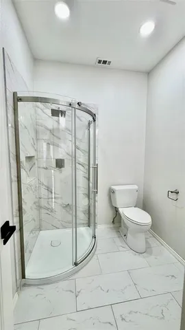 a bathroom with a toilet and a shower