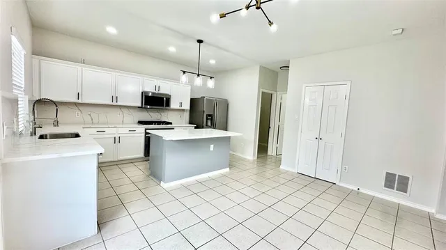 a kitchen with stainless steel appliances a refrigerator sink and microwave