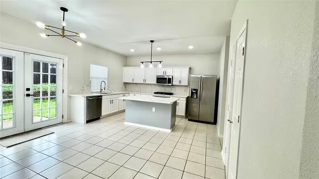 a kitchen with stainless steel appliances a refrigerator sink and microwave