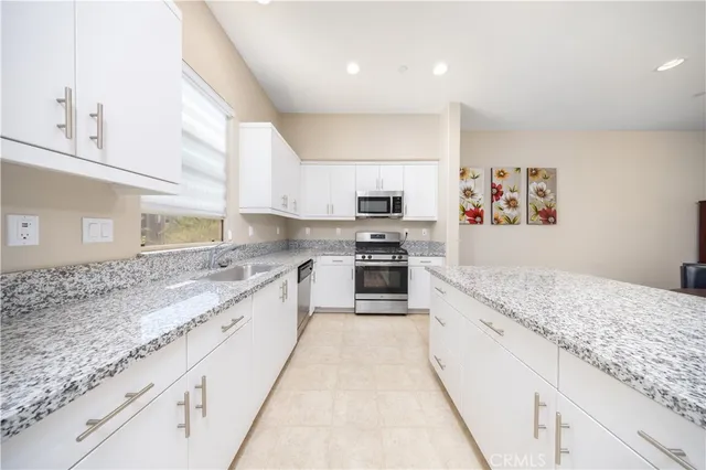a large kitchen with stainless steel appliances granite countertop a stove a sink and a granite counter tops