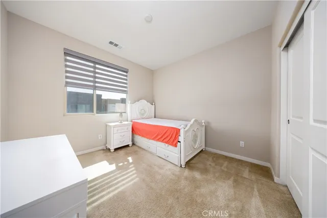 a spacious bedroom with a bed and a window